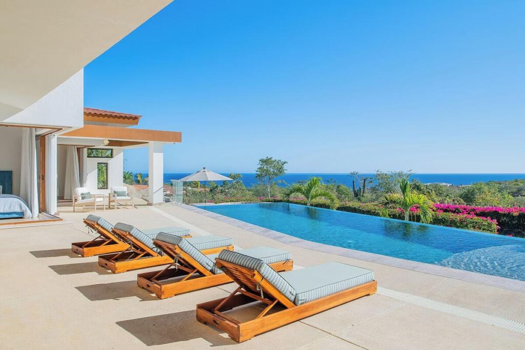 Los Cabos Jacarandas Residencia de dos niveles con 249.75 m² de construcción sobre 200 m² de terreno. Cuenta con 3 recámaras, 2.5 baños, sala con doble altura, cocina integral con barra desayunador y área de comedor con vista al patio.La recámara principal ofrece baño completo con tina tipo jacuzzi. Acabados en mármol, carpintería en tono oscuro y excelente iluminación natural. Patio amplio ideal para reuniones y cochera con portón eléctrico.Ubicada en zona residencial cercana a servicios y vialidades principales. – 187 Padre Sistiaga, San Jose del Cabo, BS